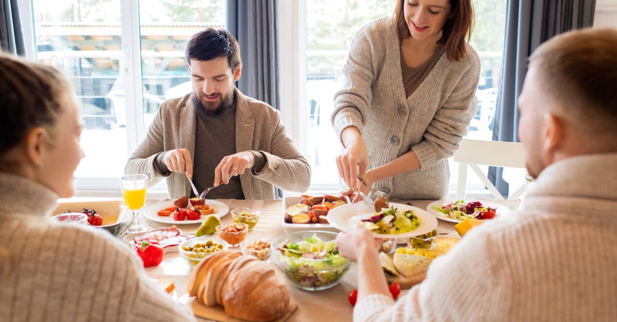 Four friends sharing a delightful meal indoors, highlighting friendship and togetherness.